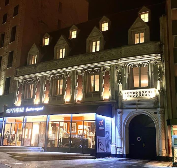 a building with a store in front of it at night at Hôtel QUAI33 in Saint-Étienne