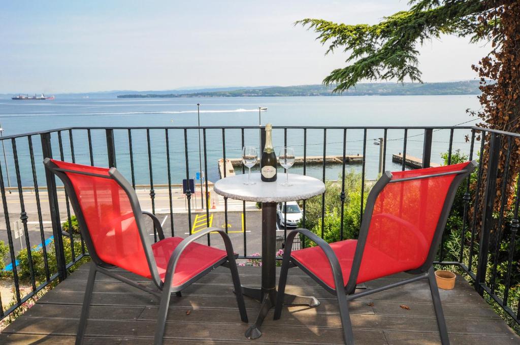 a table and two chairs on a balcony overlooking the water at Bellevue Molet apartments Koper in Koper
