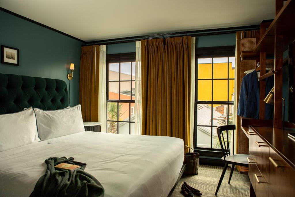 a hotel room with a bed and a large window at Hotel Emeline in Charleston