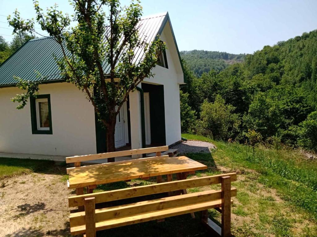 a wooden bench in front of a small house at Zelena livada (Green Meadow) in Bijelo Polje