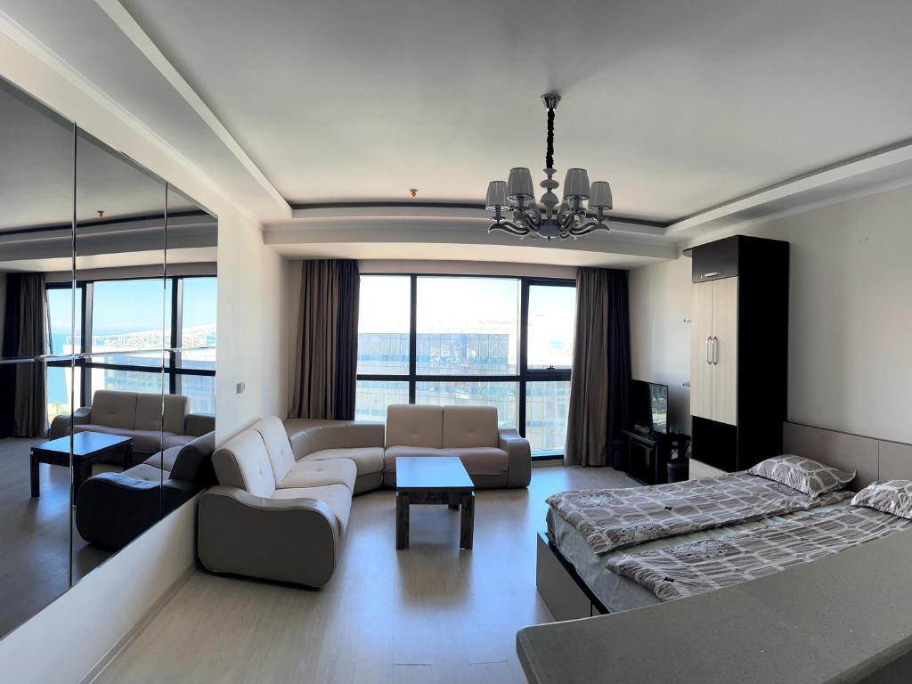 Angel Apartment in Porta Batumi في باتومي: غرفة معيشة مع سرير وأريكة