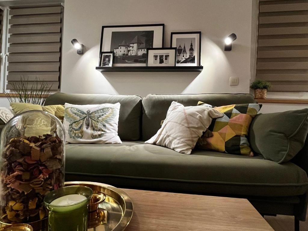 a green couch in a living room with a table at Jourek Apartment in Varaždin