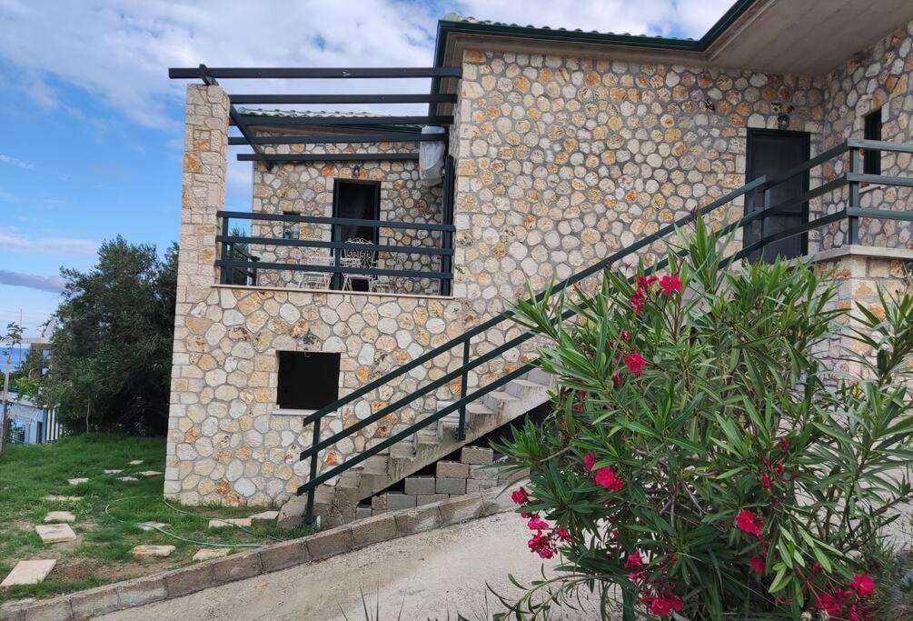 Edificio de piedra con escaleras y balcón en Korina's house, en Loutsa