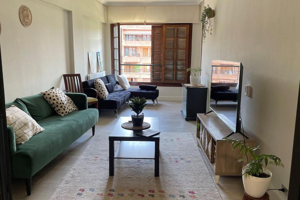uma sala de estar com um sofá verde e uma televisão em Apartamento céntrico en Azpeitia em Azpeitia