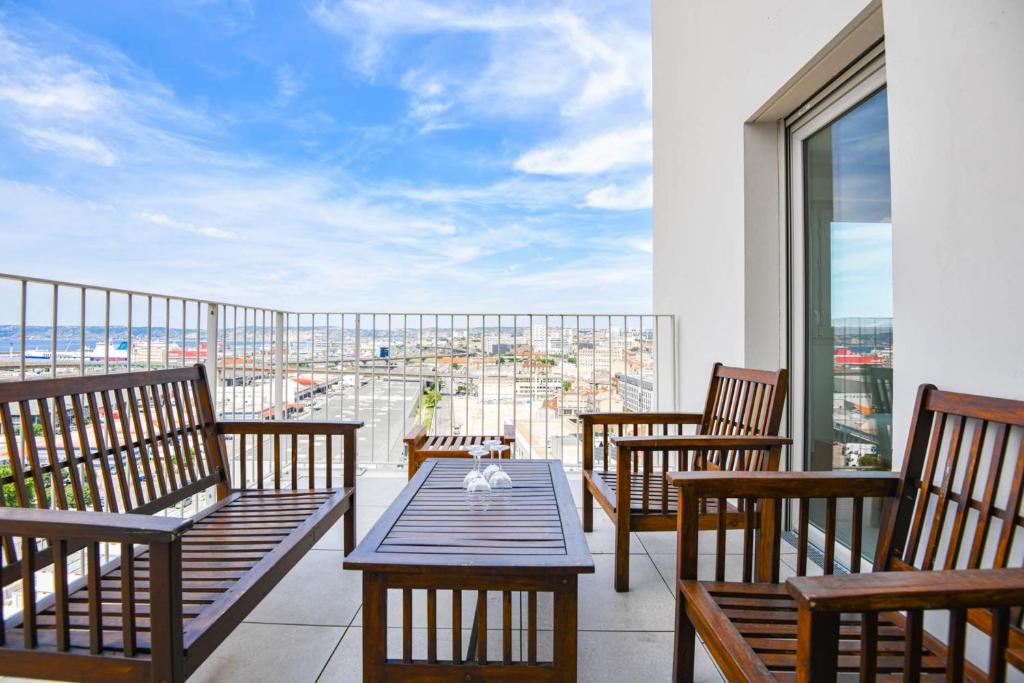 een balkon met stoelen en een tafel met uitzicht bij Le Ruffi - Appart 1 ch avec terrasse et parking in Marseille