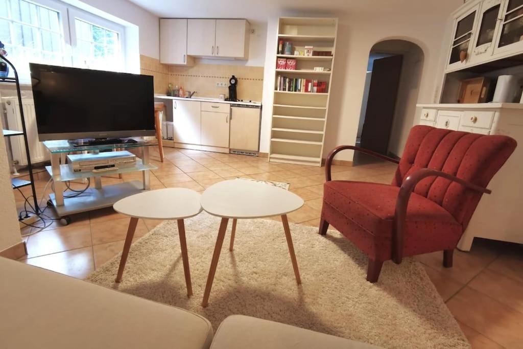 sala de estar con silla roja y TV en Schöne Wohnung für einen Kurzurlaub in Lüneburg, en Lüneburg