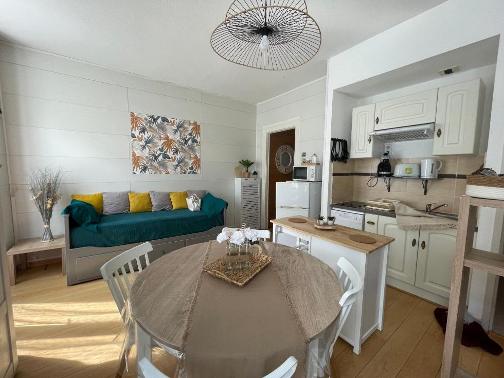 een keuken en woonkamer met een tafel en een bank bij Ô Cocon Montagnard in Eaux-Bonnes