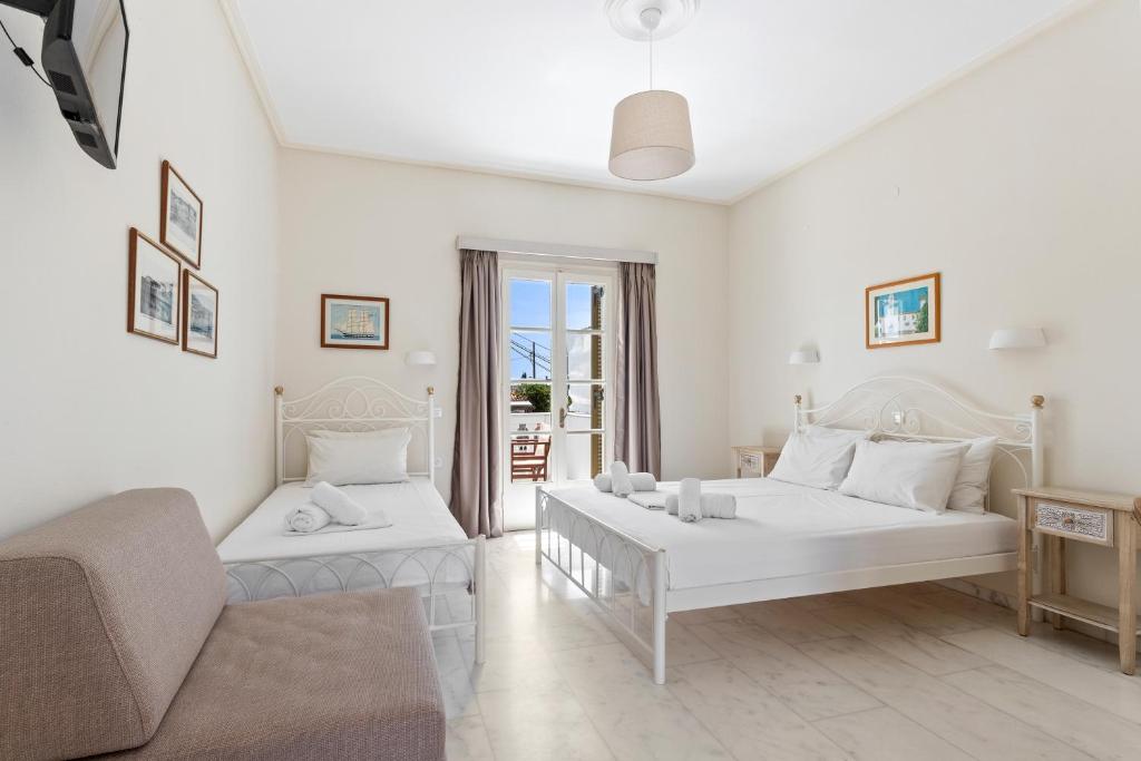 a living room with two white beds and a couch at Villa Kalomira in Spetses
