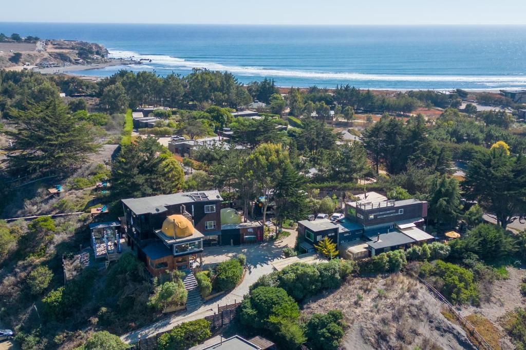 una vista aerea di una casa e dell'oceano di Sirena Insolente Hostel & Suites a Pichilemu