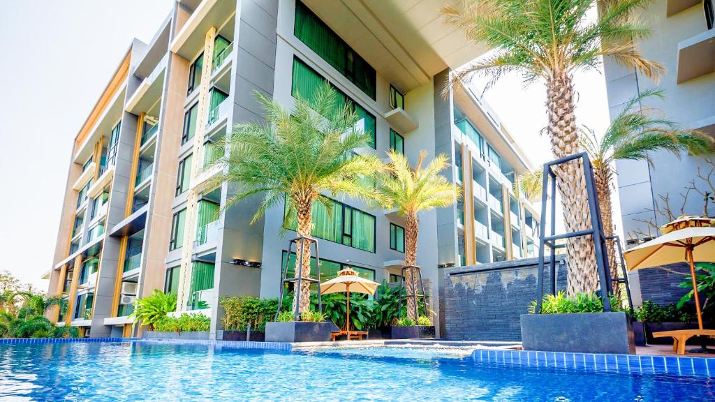 ein Hotel mit Palmen und einem Pool in der Unterkunft The Star Hill Condo Luxury Suites in Chiang Mai