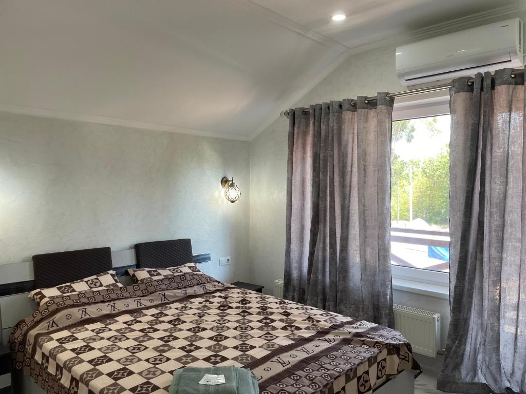 1 dormitorio con cama y ventana en Villa aeroport розовый дом, en Chişinău