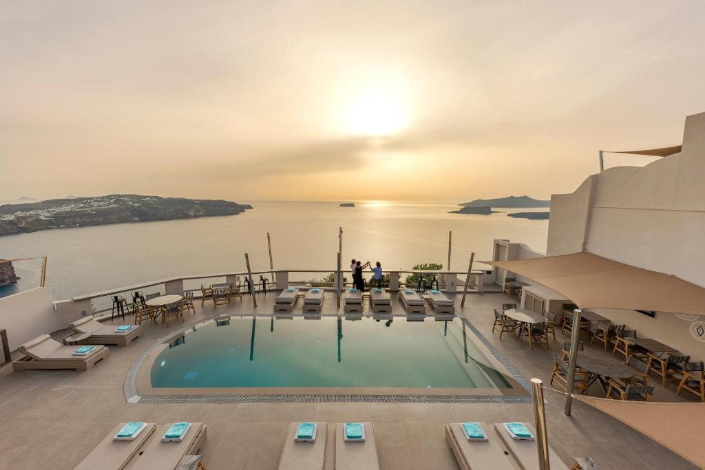 a swimming pool on a cruise ship with the sun setting at Grand View - Megalochori Santorini in Megalokhori