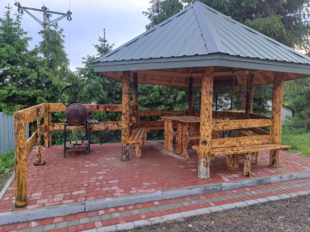 a wooden gazebo with a table and a grill at Noclegi u Wandy in Ropienka