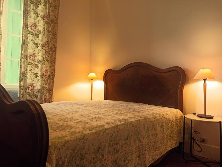 - une chambre avec un grand lit et deux lampes dans l'établissement Maison de la Rivière, à Clamecy