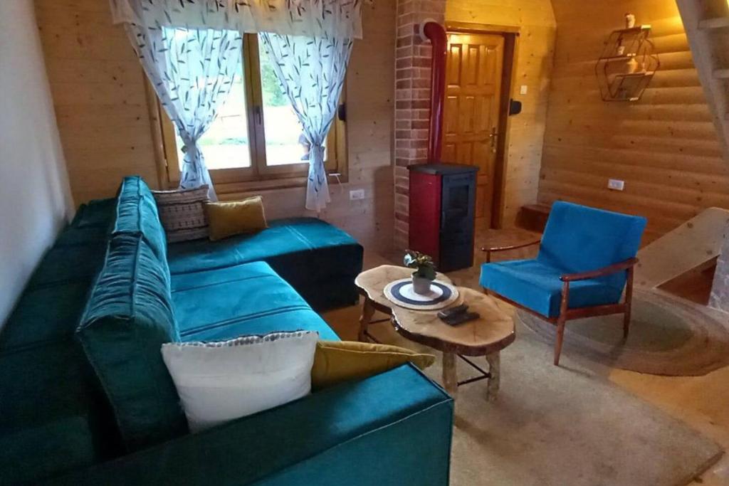 a living room with a blue couch and a table at Durmitor Chill Chalet in Žabljak