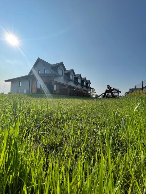dom w środku pola trawy w obiekcie K&J Domki Letniskowe w mieście Będzino
