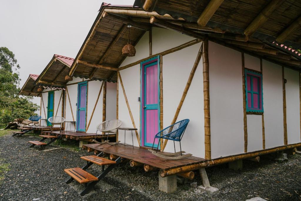 a row of houses with colorful windows and a wooden table at Selina Quindio in Filandia