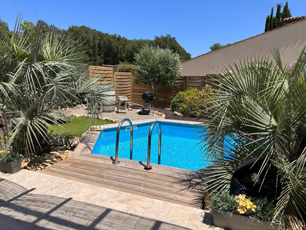 een zwembad met een houten terras naast bij Lou Colibri in Le Thoronet