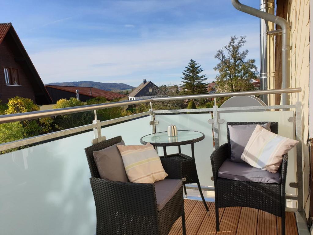 einen Balkon mit 2 Stühlen und einem Tisch auf einer Terrasse in der Unterkunft Ferienwohnung Laura in Langelsheim