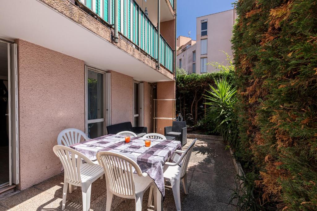 a table and chairs on the balcony of a building at Appartement familial avec jardin ensoleillé dans la cité des Potiers in Vallauris