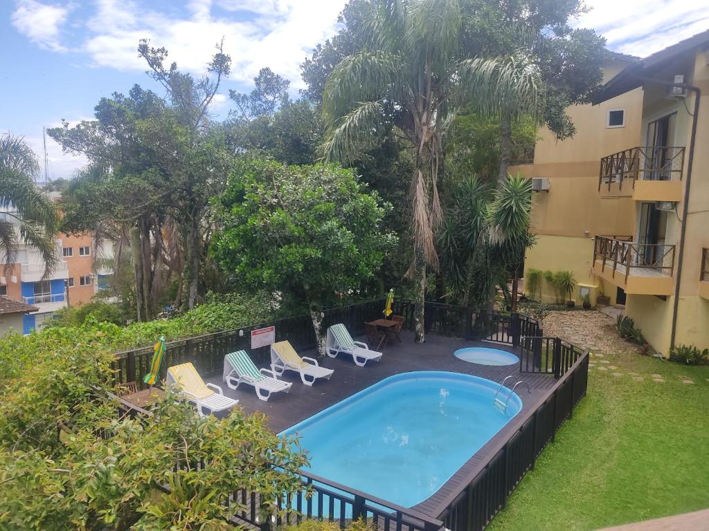a swimming pool in a yard next to a building at Pousada Aquarela de Bombinhas in Bombinhas