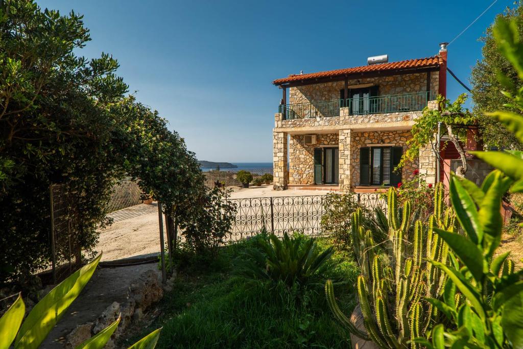 una casa de piedra con una valla delante de ella en Agnadia Villa en Stalos