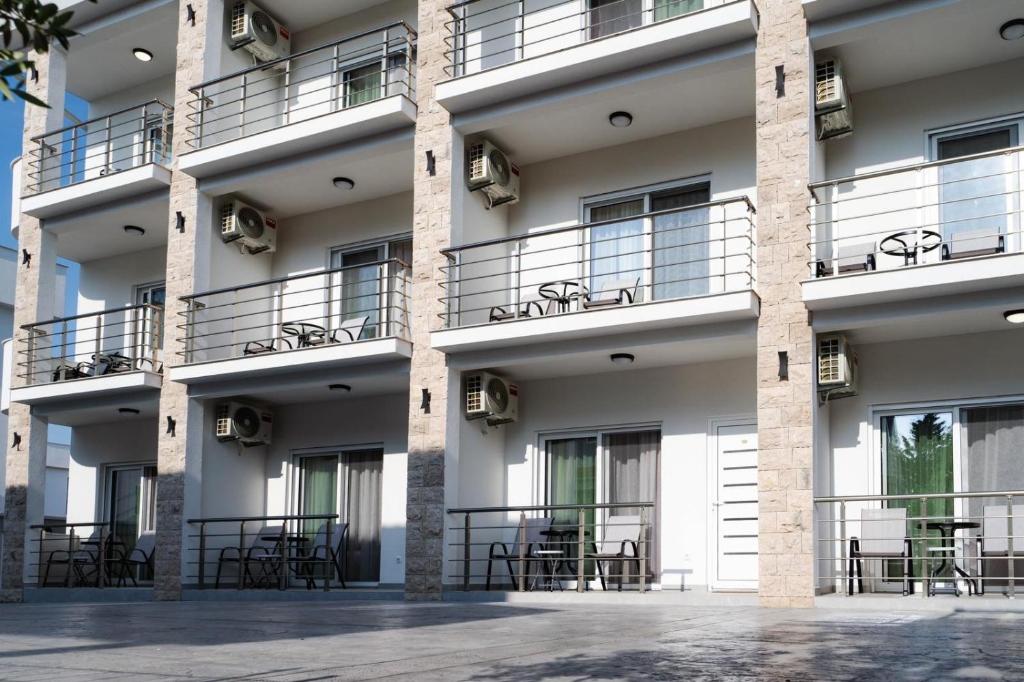a facade of a building with tables and chairs at Apartments Ali in Ulcinj