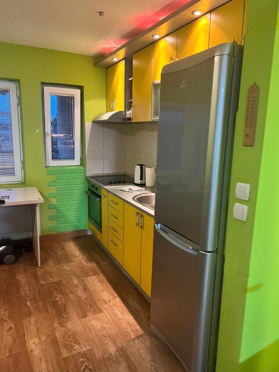 a kitchen with yellow and green walls and a refrigerator at Greenspace in Niš