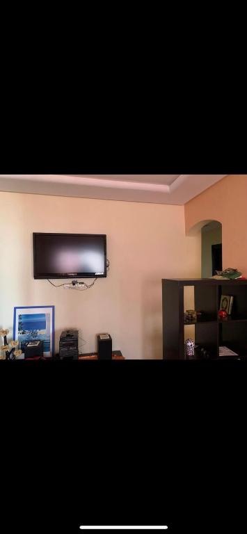 sala de estar con TV de pantalla plana en la pared en Costa cabo en Martil