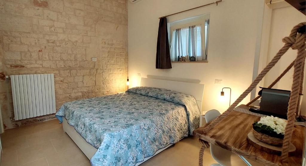 アルベロベッロにあるMirum Apuliaeのベッドルーム1室(ベッド1台、ノートパソコン付きのテーブル付)