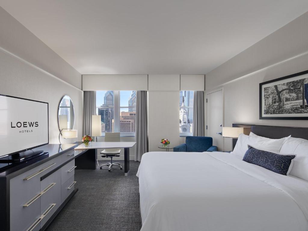 フィラデルフィアにあるロウズ フィラデルフィア ホテル の大きなベッドとデスクが備わるホテルルームです。