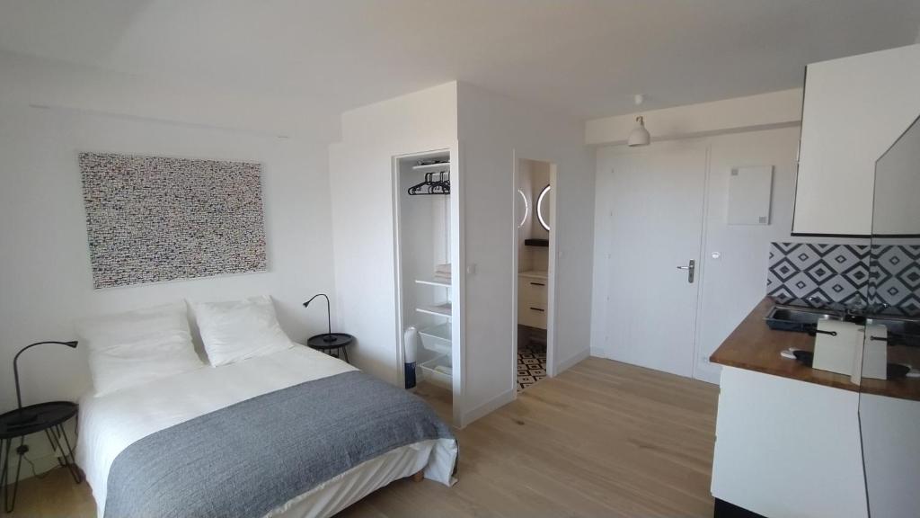 een witte slaapkamer met een bed en een keuken bij La Junior Suite in Soorts-Hossegor