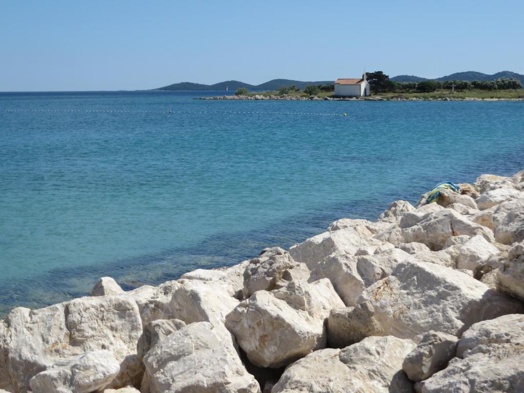 eine Gruppe von Felsen am Ufer eines Wasserkörpers in der Unterkunft Sweet Sea Apartments in Pakoštane