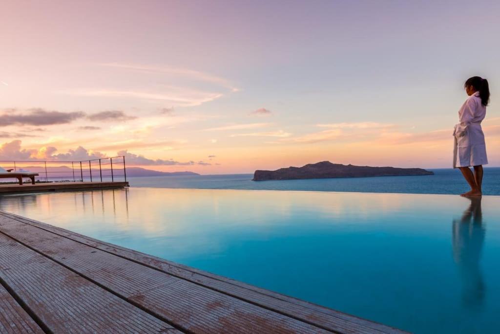 a woman standing on the edge of a body of water at Villa Pasiphae in Stalos