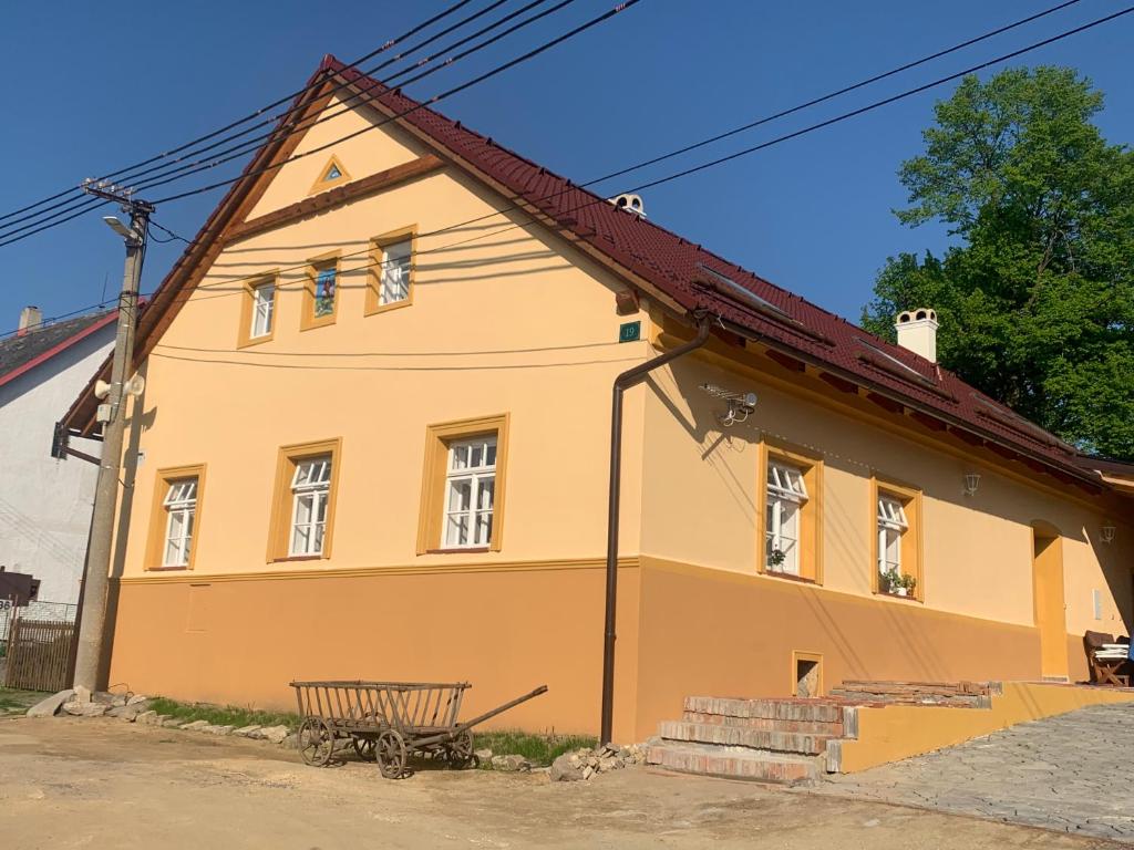 een geel huis met een bankje ervoor bij Chalupa Gretl in Pohorsko