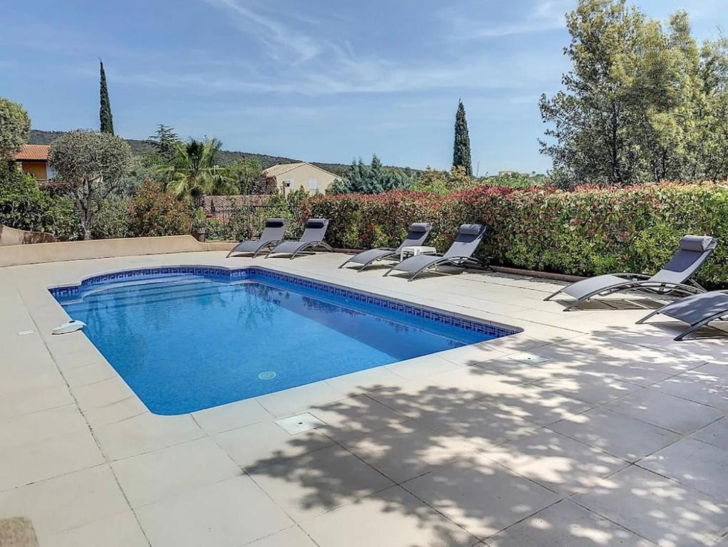 uma piscina com espreguiçadeiras ao lado em Villa sainte maxime golfe de Saint Tropez em Sainte-Maxime