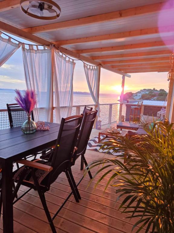 a wooden deck with a table and chairs and the ocean at La Vista in Drage
