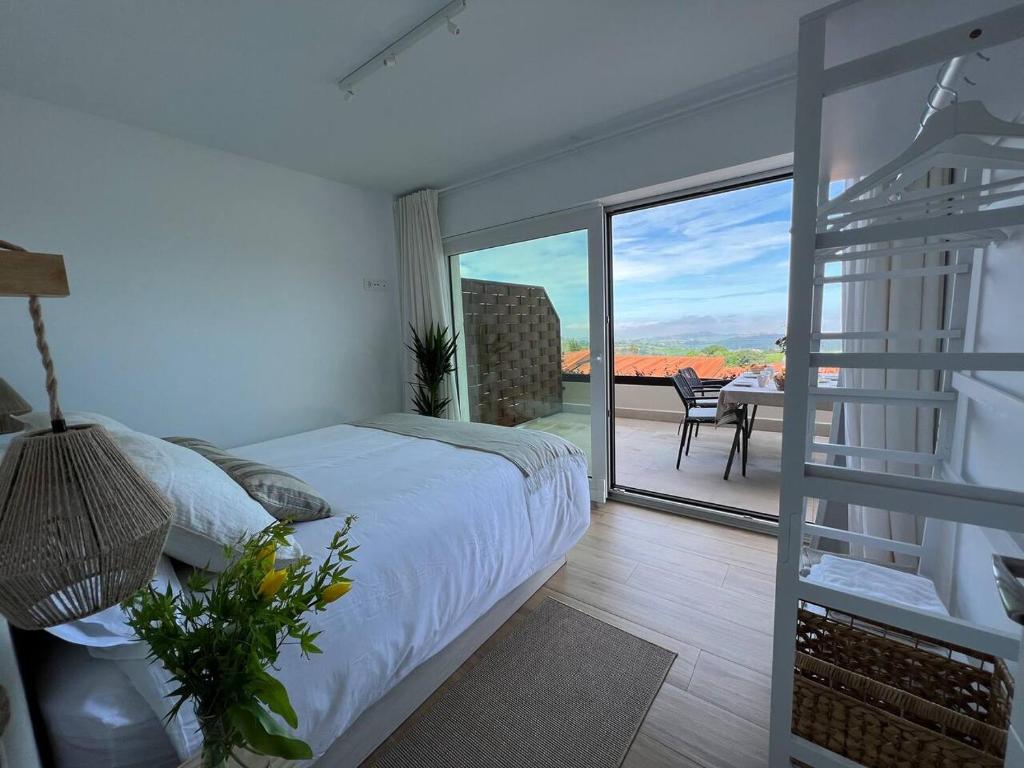 - une chambre avec un lit et un balcon avec vue dans l'établissement Puerta de Comillas - El Mirador de Canales, à Canales