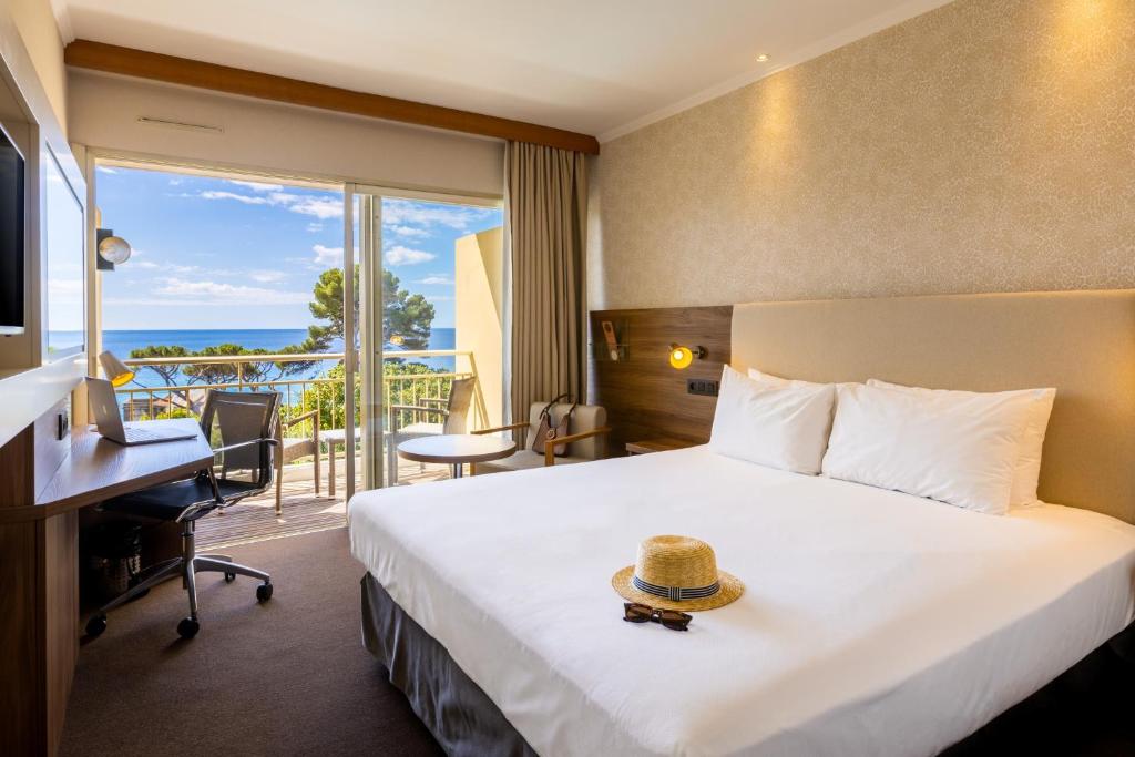 una habitación de hotel con una cama con sombrero en Luxotel Cannes, en Cannes