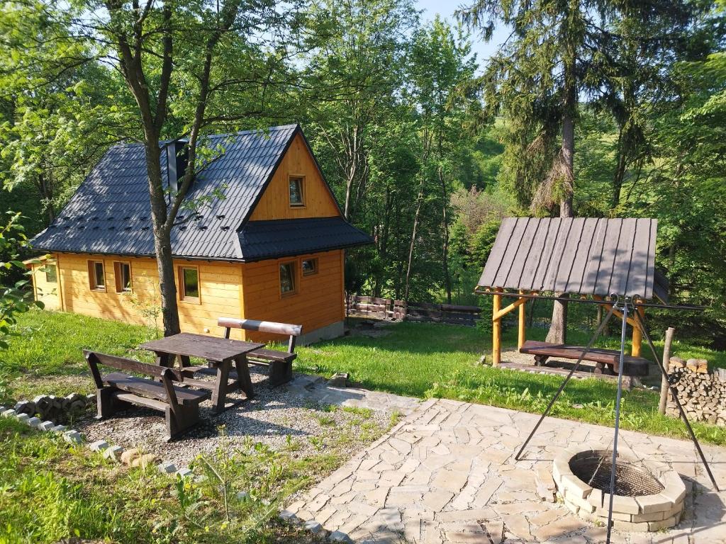 a wooden cabin with a picnic table and a gazebo at Za Potokiem in Grywałd