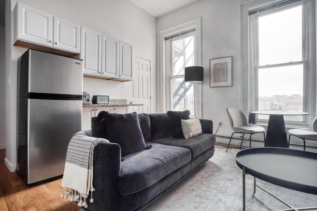 uma sala de estar com um sofá e um frigorífico em Well-located S Boston 1BR on E Broadway BOS-473 em Boston
