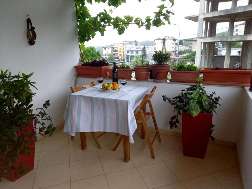 a table with a bottle of wine and fruit on a balcony at GuestHouseMantho in Gjirokastër