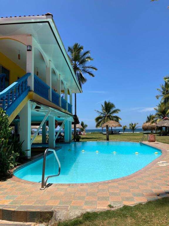 a swimming pool in front of a house at Las Lajas Beach Resort in Las Lajas