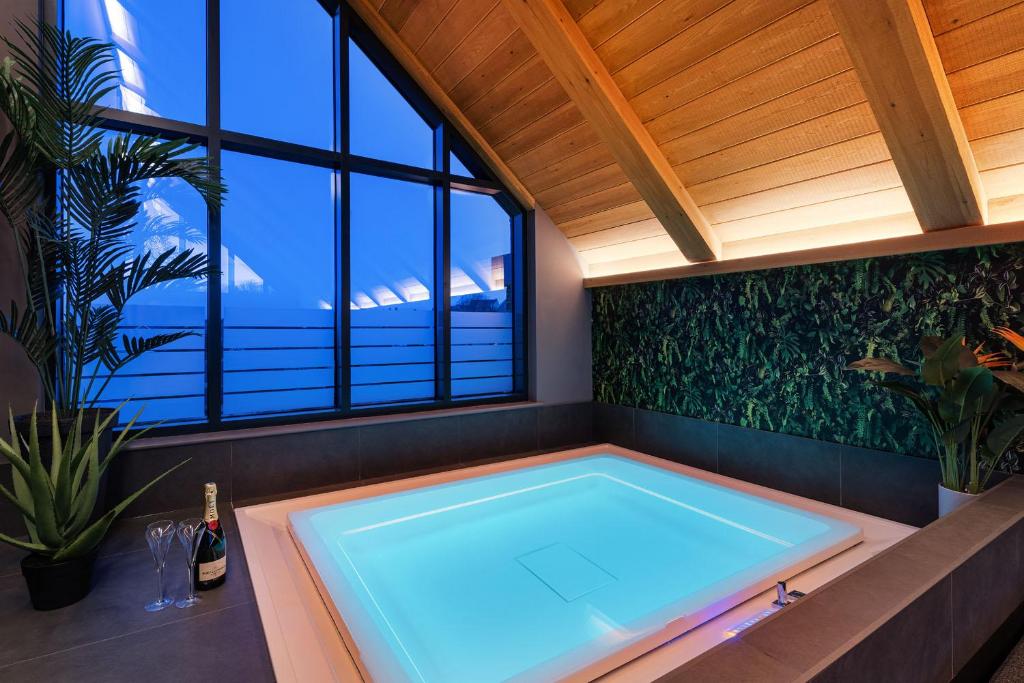 a hot tub in a room with a large window at Marina West - Amble, Northumberland in Amble