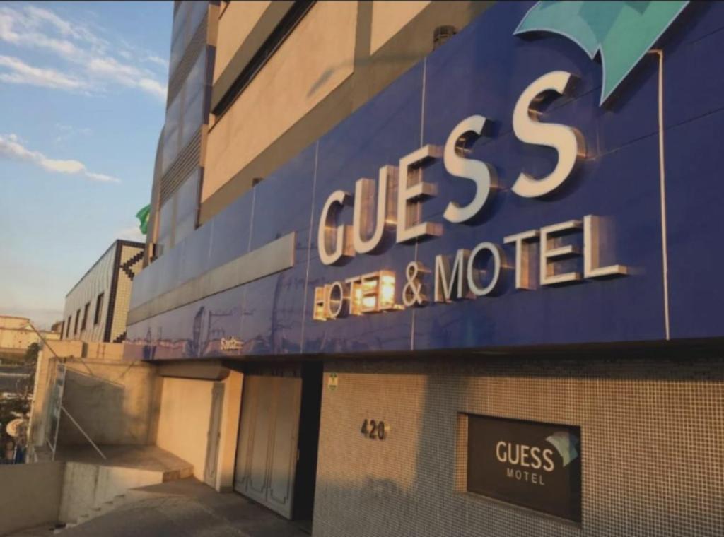 un bâtiment avec un panneau bleu sur son côté dans l'établissement Guess Hotel & Motel, à Guarulhos