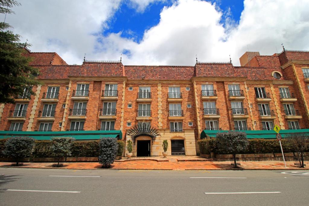 um grande edifício de tijolos com um toldo verde em Hotel Windsor House Inn By GEH Suites em Bogotá