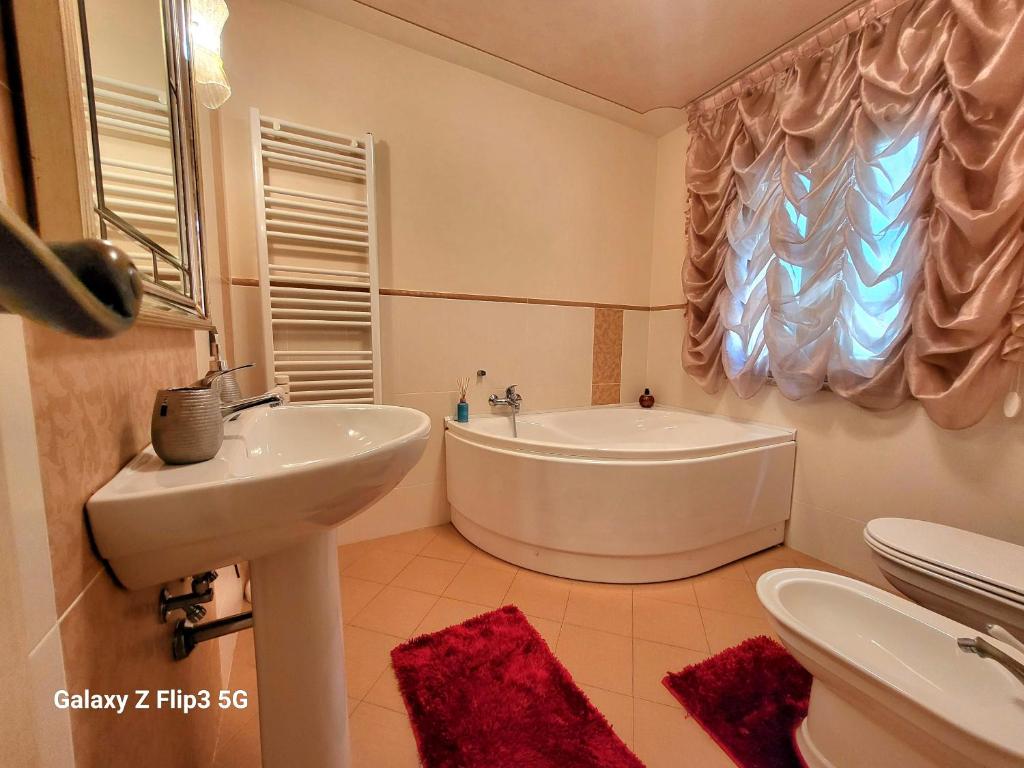 a bathroom with a tub and a sink and a toilet at Queen House in Montopoli in Val dʼArno