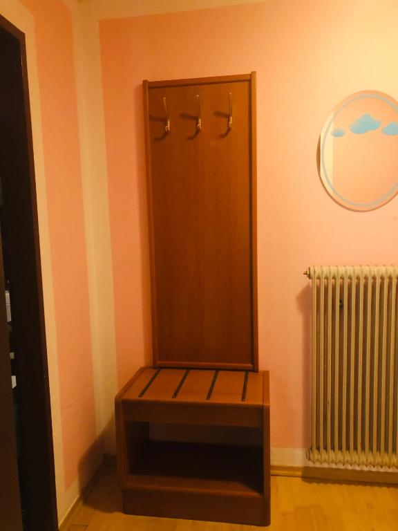 a bench in a room with a mirror and a radiator at Holmes Café & Pension in Engelhartszell