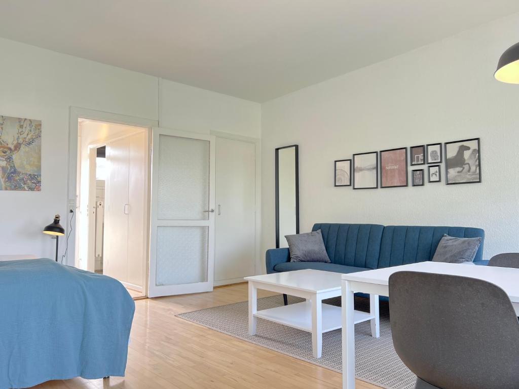 a living room with a blue couch and a table at Studio Apartment In Herlev, Herlevgrdsvej 4, in Herlev