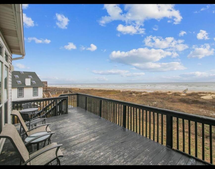 a balcony with chairs and a view of the ocean at Beachfront Envy in Galveston